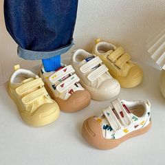 子供が口を開いてビスケットの靴を笑います。