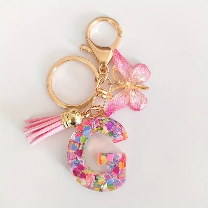2024 transfronteriza en stock resina rosa con lentejuelas 26 letras inglesas llavero colgante mariposa borla Accesorios