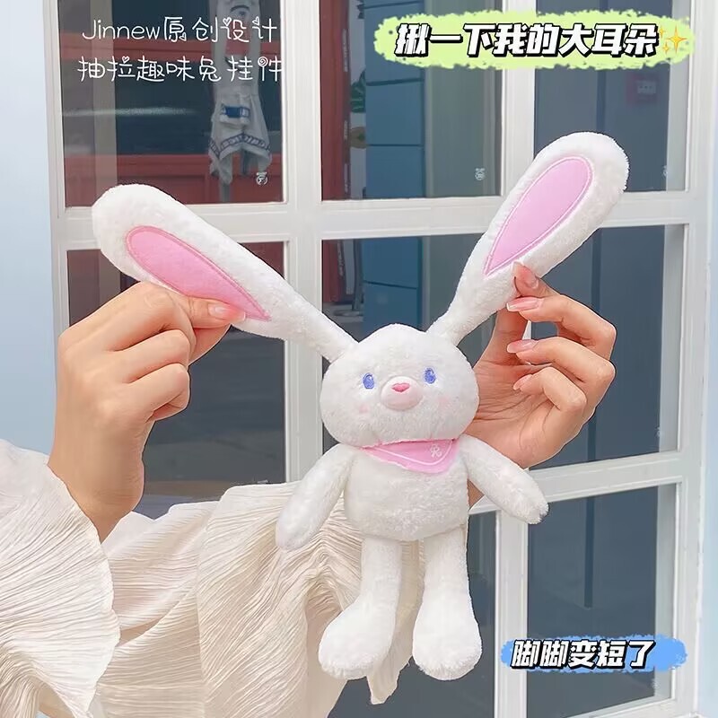 ネットの赤い耳のウサギはウサギの鍵を引いてぬいぐるみのかばんのペンダントを掛けて女の子にプレゼントします。|undefined