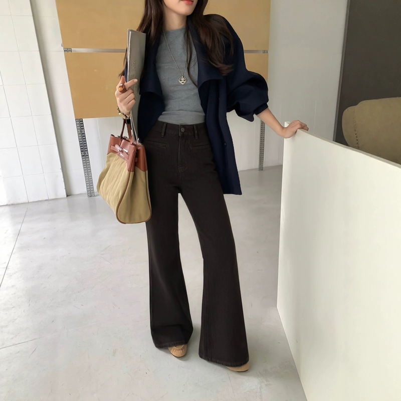 Women's loose-fit, four-way stretch, slightly flared jeans in coffee color for Autumn 2026. High-waisted, with a drapey silhouette that covers the hips, offering a slimming effect