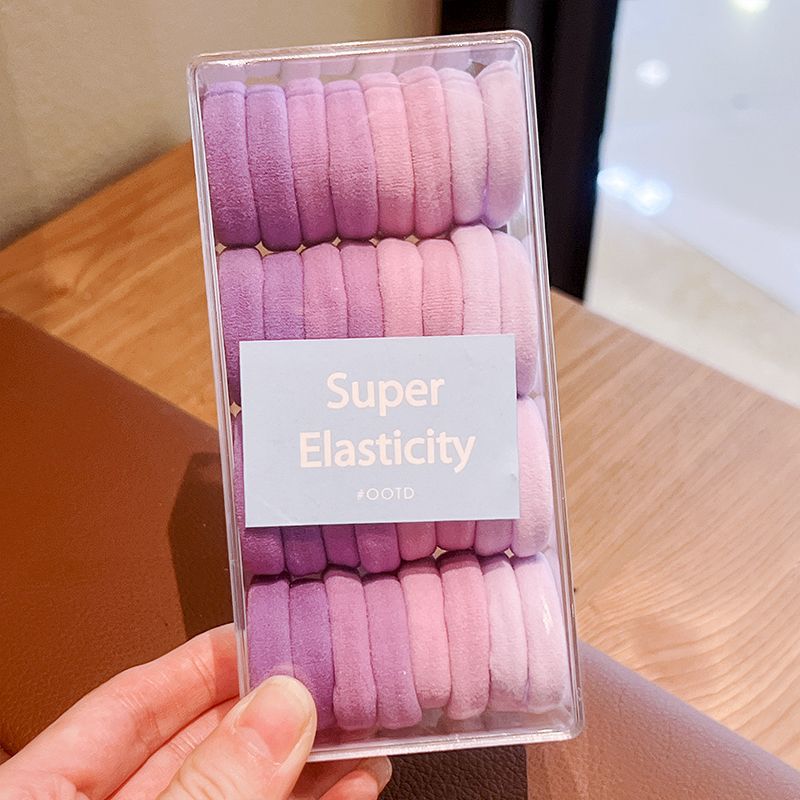 32 cajas de anillos de pelo morado