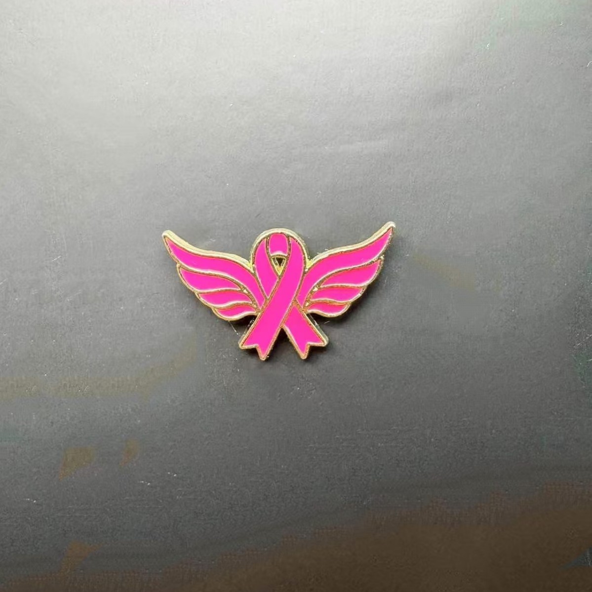 Broche promotionnelle avec logo du Ruban Rose International, symbole de sensibilisation au cancer du sein_voghion.com