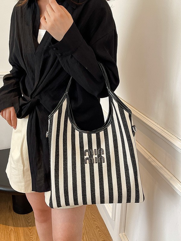 Bolsa de hombro a rayas de lona 2026 nueva sensación de lujo ligera casual diaria gran capacidad mochila