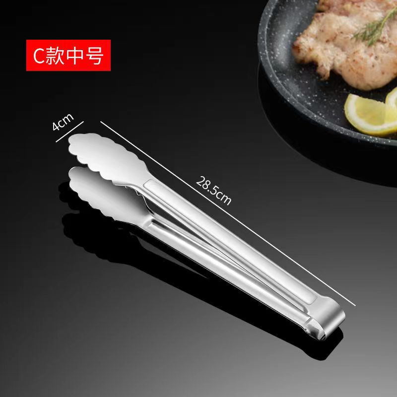 ステンレスの食品は台所の焼肉を挟んでステーキを焼きます。|undefined