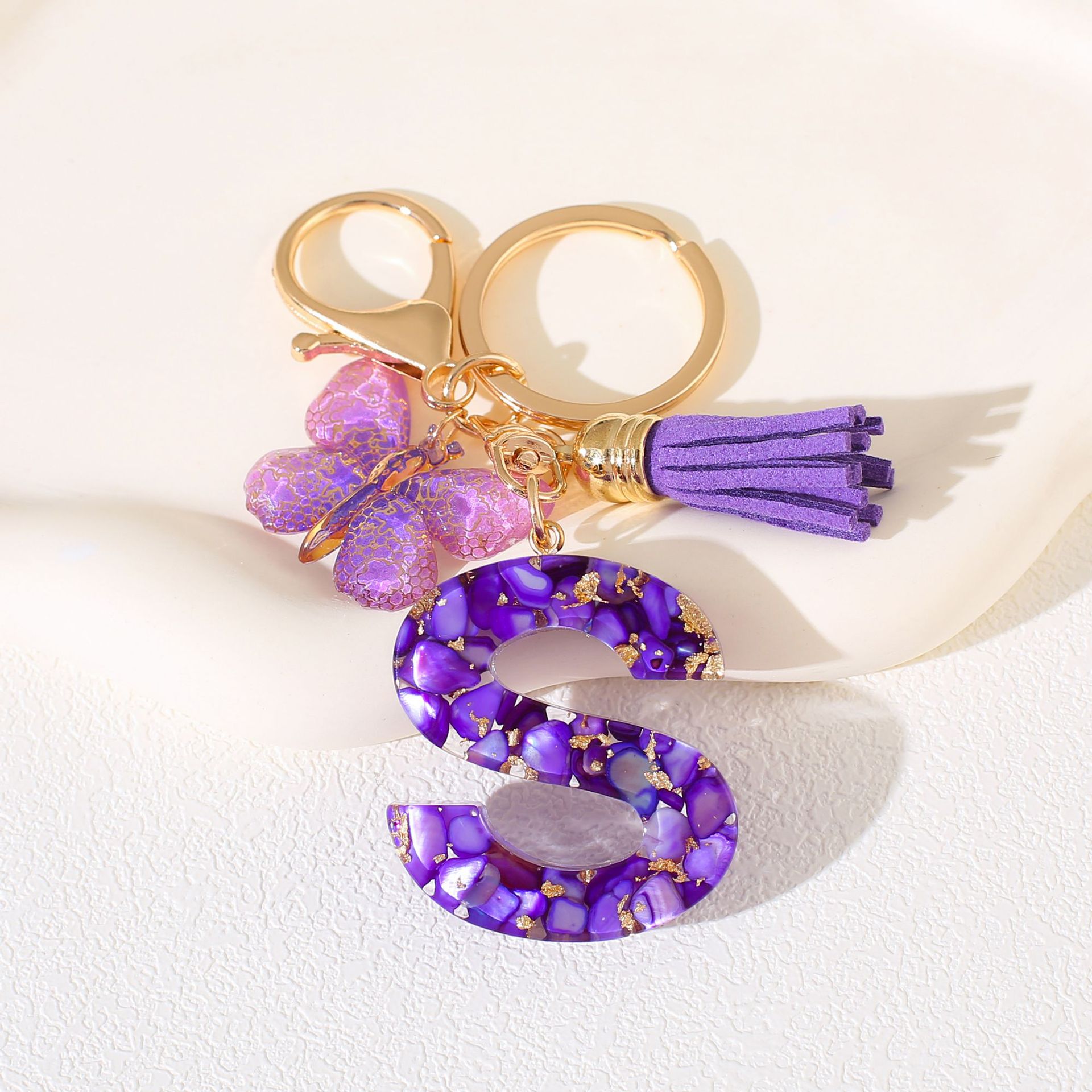 Fábrica directa de Yiwu accesorios de resina de goteo de embalaje llavero anillo de metal letras mariposa brilla colgante damas