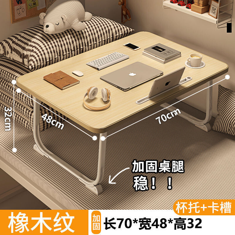 ベッドの上の小さい机のノートパソコンの机の上で折り畳みます。|undefined