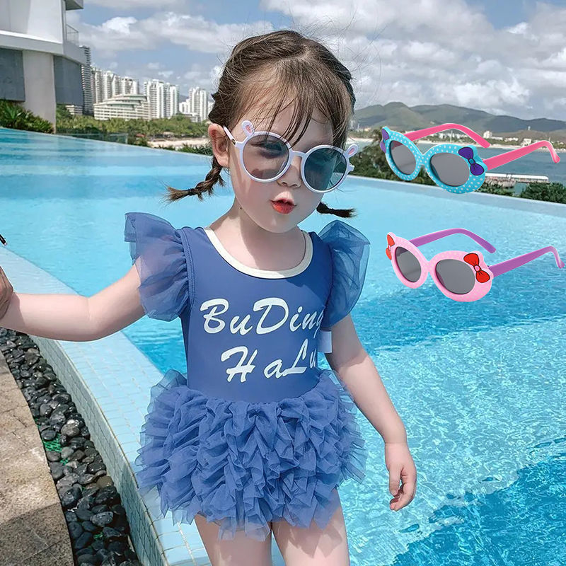 Niña bañador azul con gafas de sol