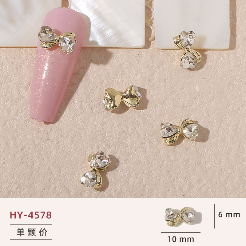 Uñas mariposa joyería nueva línea popular perla arco metal decoración de uñas pequeños accesorios de joyería al por mayor