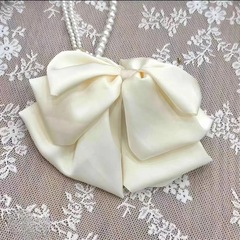 フレンチサテンの蝶結びの花のつぼみは女性の後頭部のふんわりとした髪の量を表します。