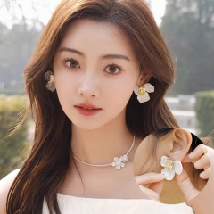 ジルコンの板材をつけた花のピアスの女性のデザイン感が小さいレトロなイヤリングの個性が合っています。