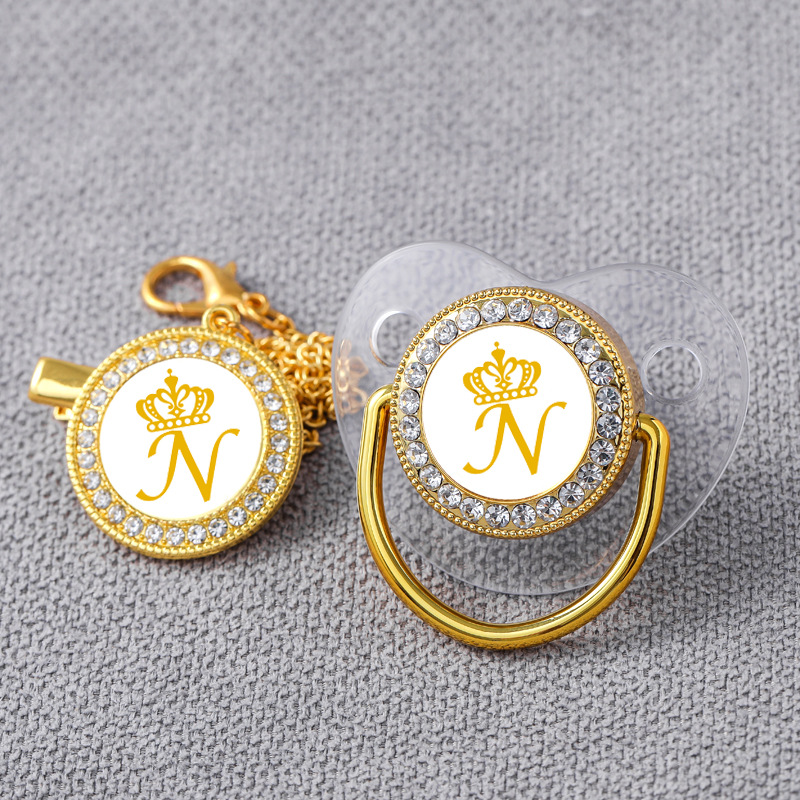 AliExpress Venta caliente oro transparente 26 corona carta bebé punto taladro jugando boca con diamante bebé chupete de oro