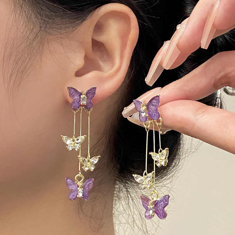 Pendientes de diseño de nicho de moda y exquisito todo fósforo Pendientes de temperamento de hadas Pendientes de borla de mariposa de cristal púrpura