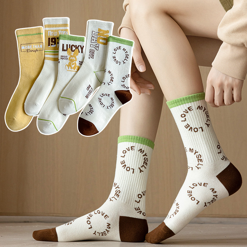 Calcetines de algodón de color puro Mediados de la pantorrilla de las mujeres Otoño e invierno Letras blancas Calcetines de marea de alta elástico Calcetines deportivos al por mayor