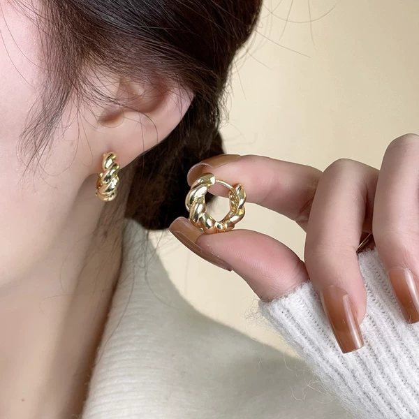 Metal glossy golden earrings with pigtail