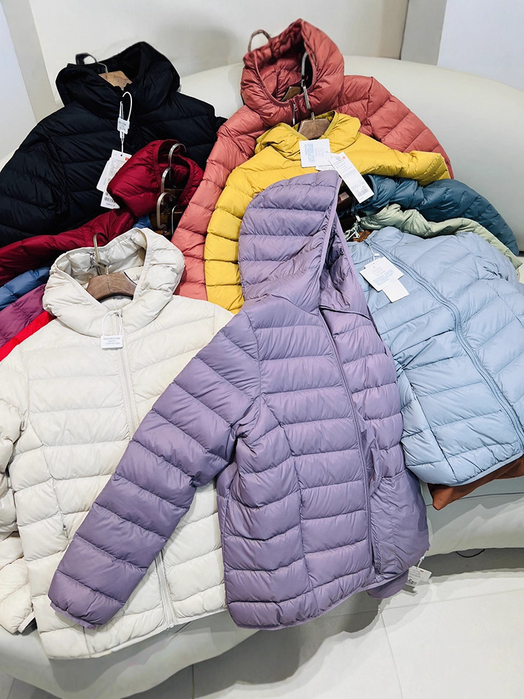 Chaqueta de plumón ligera para mujeres otoño y invierno 2025 nueva chaqueta de plumón de costillas con capuchón corto conveniente para almacenar chaqueta pequeña