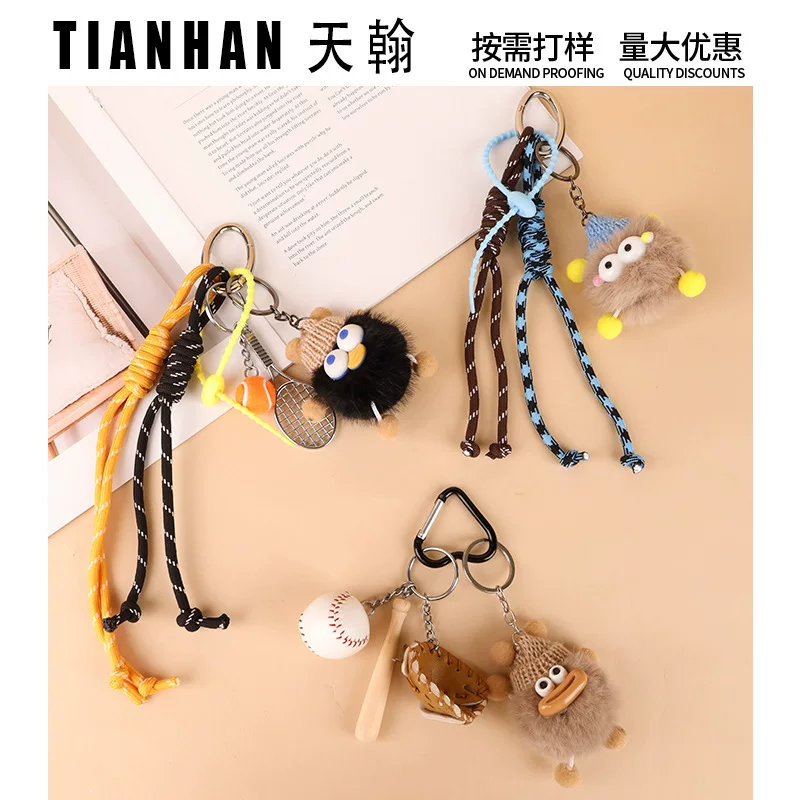 Ключодержа́тель (TIANHAN) помпон из искусственного камелика, подвеска-колбаска с мордочкой с большими глазами в виде дога, плетеная веревка 16 см