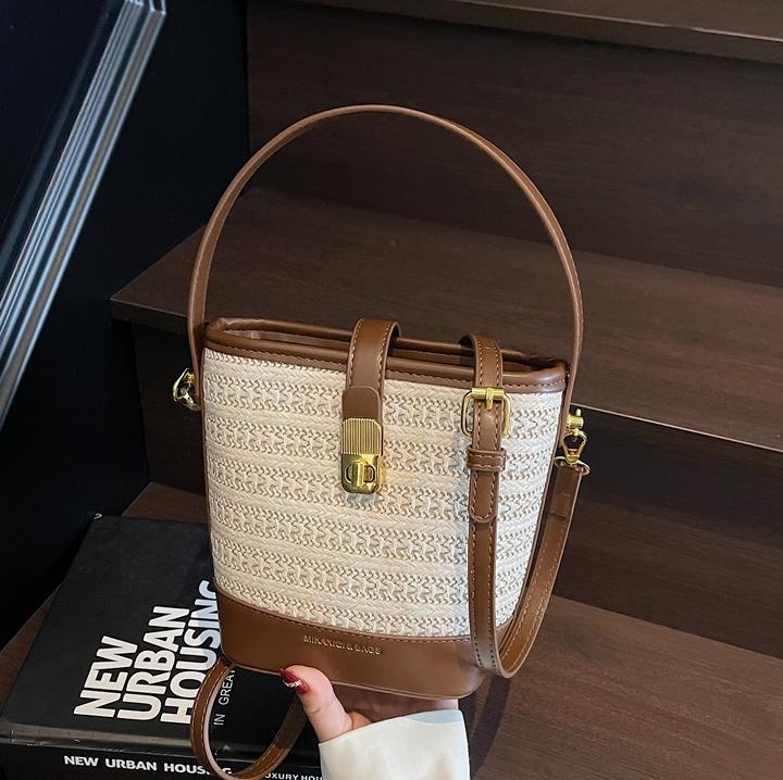 Bolso de cubo de paja de mano popular de verano 2025 nuevo bolso de mensajero tejido de vacaciones junto al mar con textura bolso femenino de todo fósforo