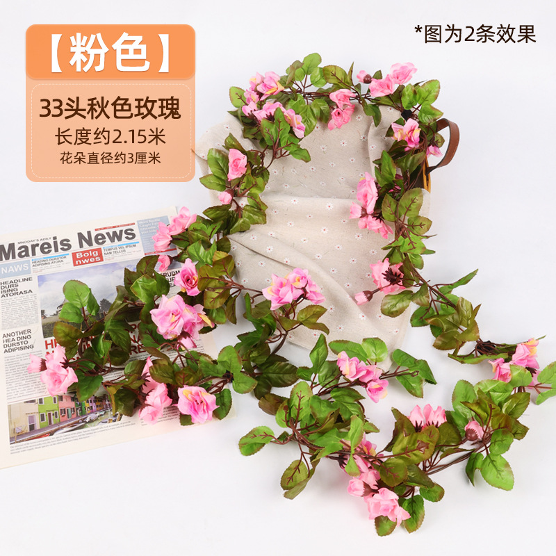 Simulación de flores falsas rosas de caña colgando la pared tubería de drenaje envuelta hoja verde que cubre la parte superior de la decoración de boda de plástico