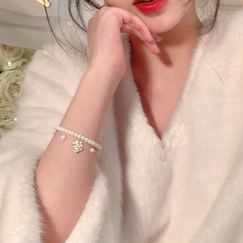 Pulsera de camelia de perlas de doble capa Pulsera ligera de lujo de alta gama, temperamento elegante y versátil, joyería de nicho de moda al por mayor