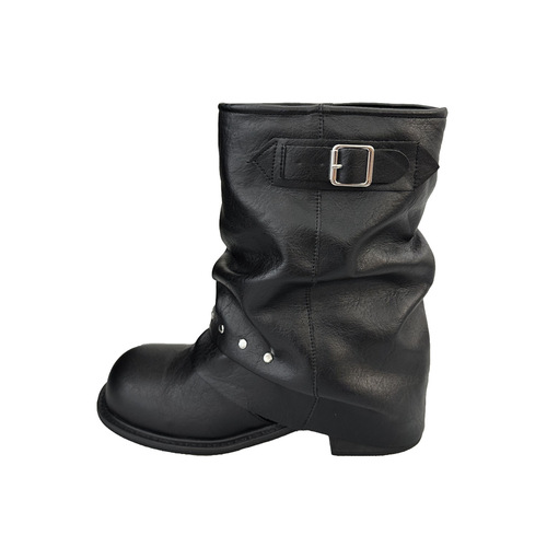 Vintage black short boots for women with new riveted trouser legs, Western boots, pleated, stacked, and motorbike boots on the trendy street.