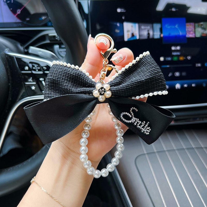 Nuevo Xiaofeng Shan camellia letra arco llavero de automóvil cadena de perlas bolsos creativos decoración colgante mujer