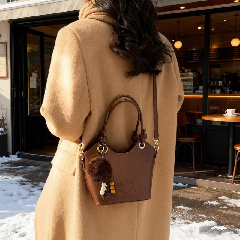 Retro alta sensación de bolso de cubo de mano 2025 invierno nuevo ocio versátil bolso de hombro de viaje mochila de mujer