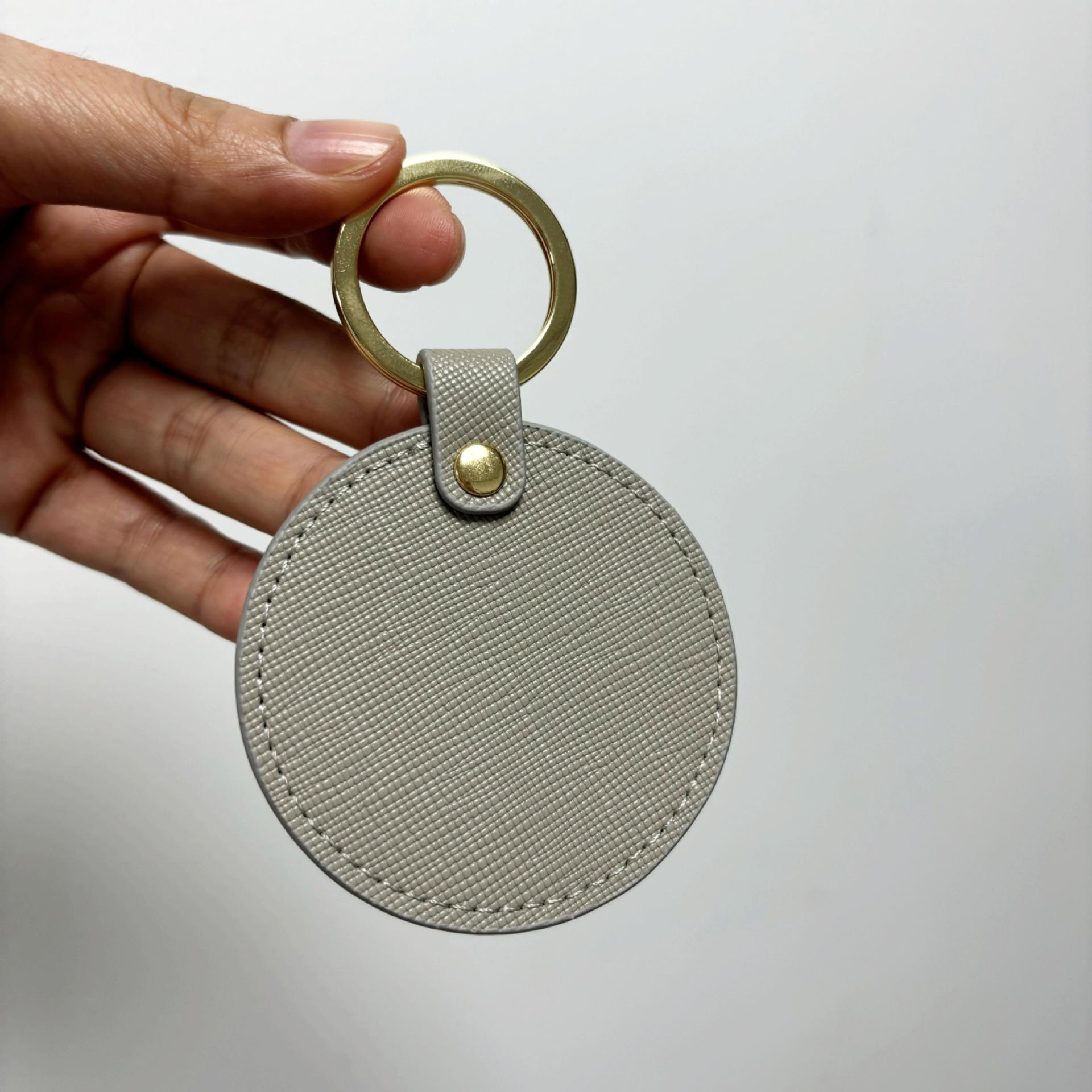 Llavero redondo de cuero genuino personalizado creativo simple colgante hombres y mujeres pequeño exquisito pequeño regalo al por mayor todo a juego