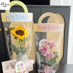 教師の日のヒマワリの花束の手は袋の花の手提げ袋のネットの赤い透明なopp袋の単一の花の包装の贈り物を持ちます。