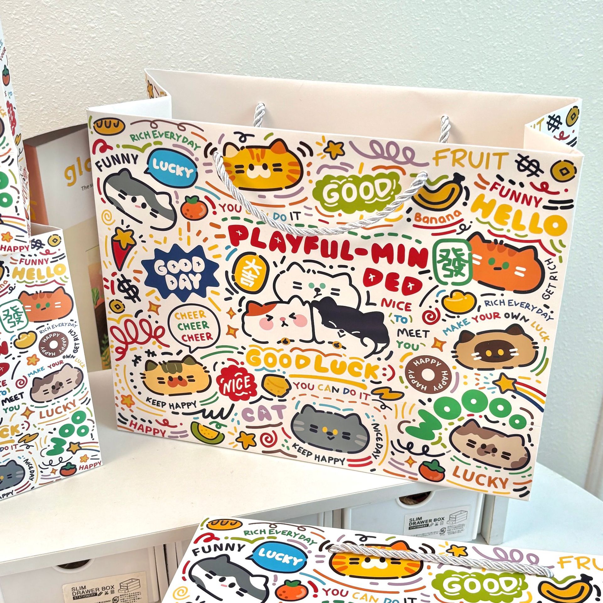 見栄えの良いギフトバッグコレクション、厚みのあるハードシェル白段ボール、大容量、シンプルで絶妙な漫画のハンドバッグ