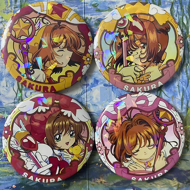 Cardcaptor Sakura merchandise: Sakura Kinomoto, Li Syaoran, Tomoyo, Kero-chan keychains, tin badges, and brooches.