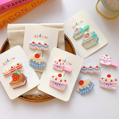 創意に合わせて子供の前髪を挟んでかわいい果物のケーキを挟みます。