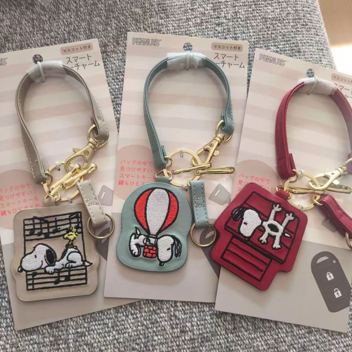 Inventario japonés Snoopy llavero colgante lindo dibujo animado exquisito bordado cuero llave de coche colgante