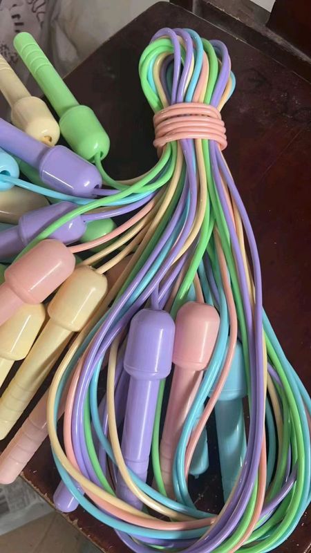 縄跳びのフィットネス運動の中で小学生の子供の縄跳びのマカロンの色の縄跳びの署名の縄跳びを訓練します。|undefined