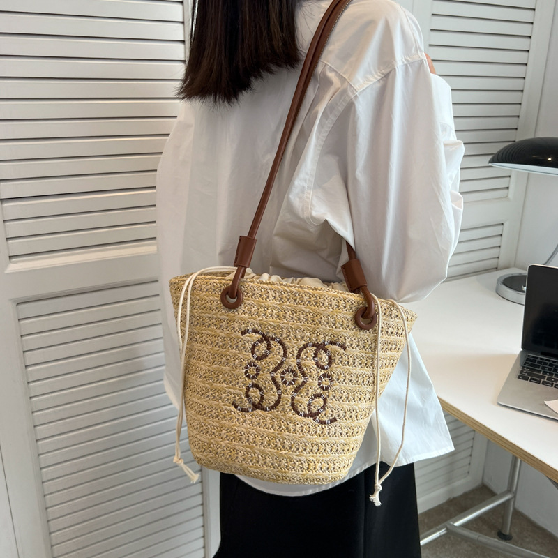 Bolsos tejidos populares de verano para damas 2025 nuevo bolso de cubo de moda de nicho de venta caliente bolso de hombro de estilo occidental de todo fósforo