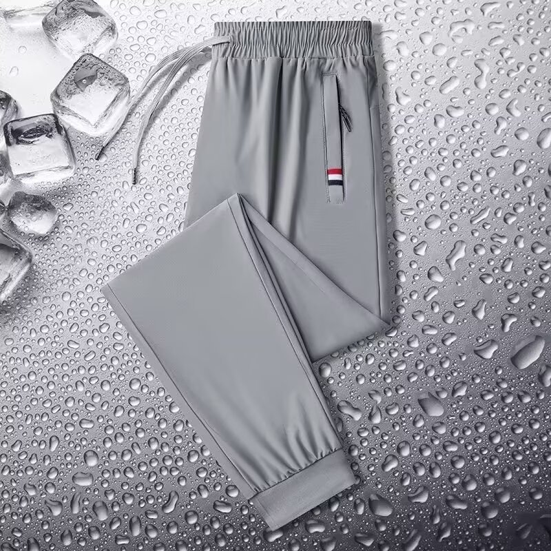 Camisas y menos ropa, pantalones de seda de hielo, pantalones de chándal elásticos finos de verano, pantalones rectos de hombre con cremallera de bolsillo al por mayor al por mayor
