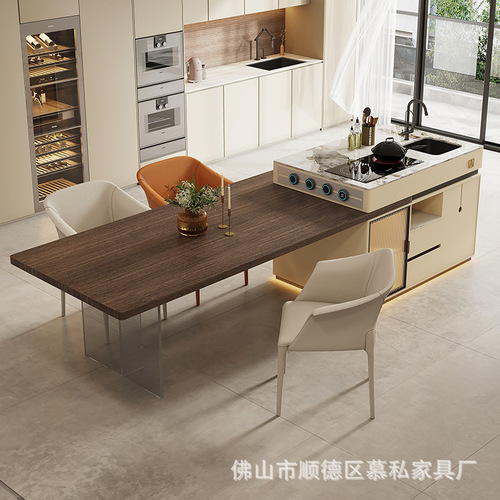 A stone slab island table with integrated tea table, induction cooktop, and extendable design, creating a versatile floating island in an open-concept kitchen.