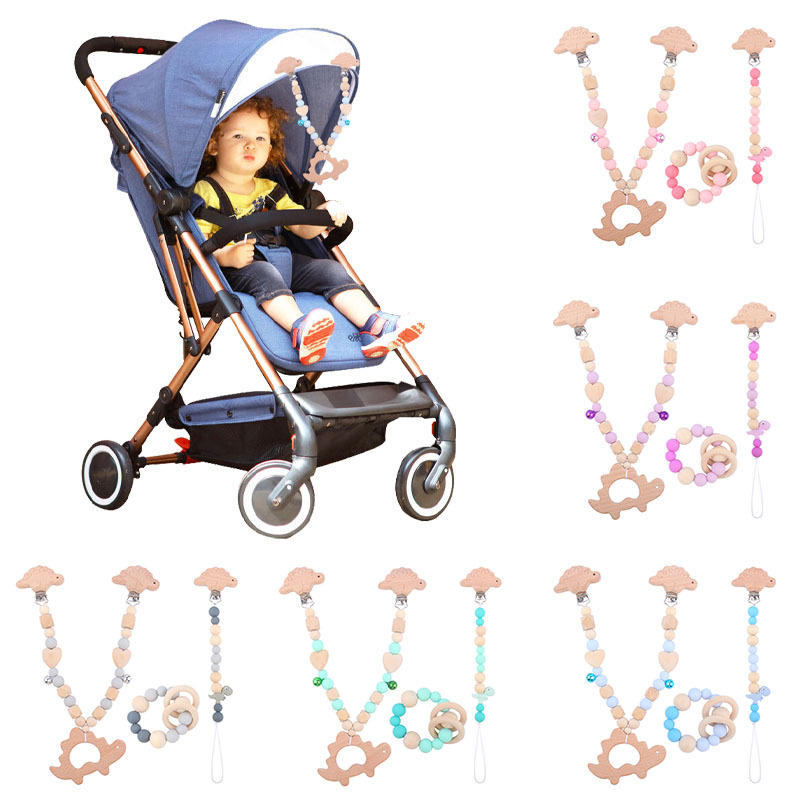 Suministros para bebés pulsera de silicona molar de juguete para niños Cadena de cochecito de dinosaurio de tres piezas creativa pequeña campana colgante