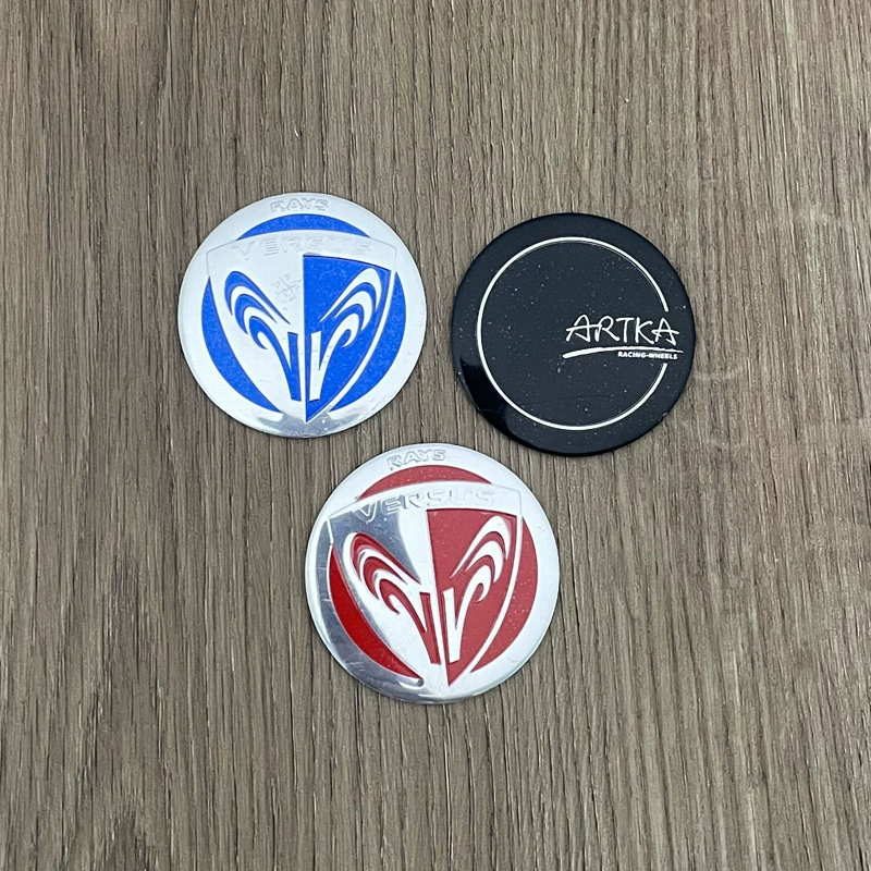 Центр крышки эпицентра деятельности 50 мм плоский обозначая против логотипа картины высокой крышки АРТКА алюминиевого