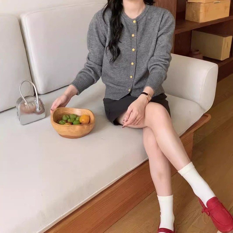 レトロで優しい風の小金はニットの女性のカーディガンを掛けます。|undefined