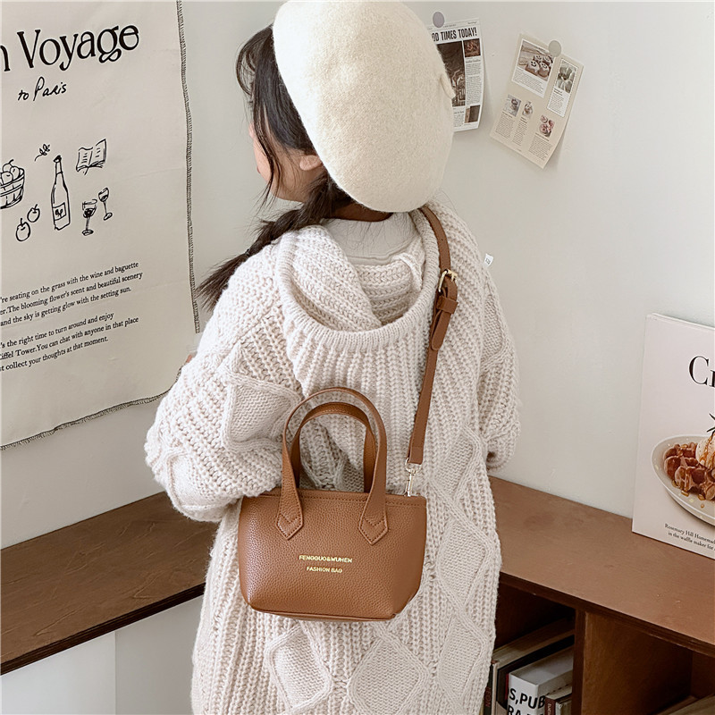 Bolsa de canasta de moda coreana para niñas simple color sólido bolso de balde de bebé 2025 nuevo bolso de comercio exterior para niños