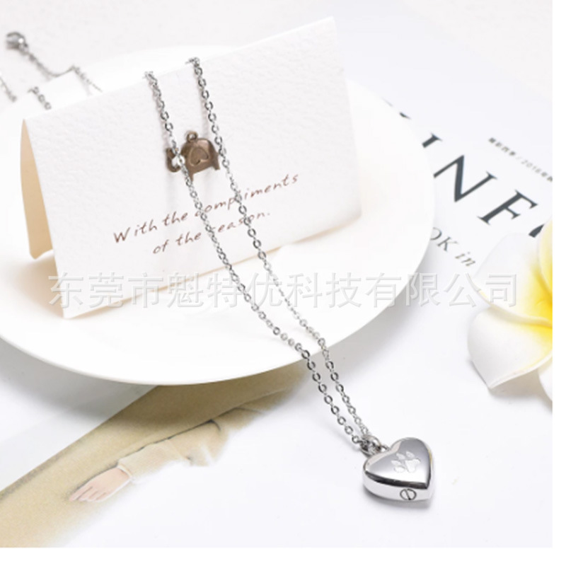Japonés y coreano nuevo collar de acero de titanio de las mujeres no se desvanece en forma de corazón pata de impresión conmemorativa gato y perro mascota cinerario ataúd colgante impermeable