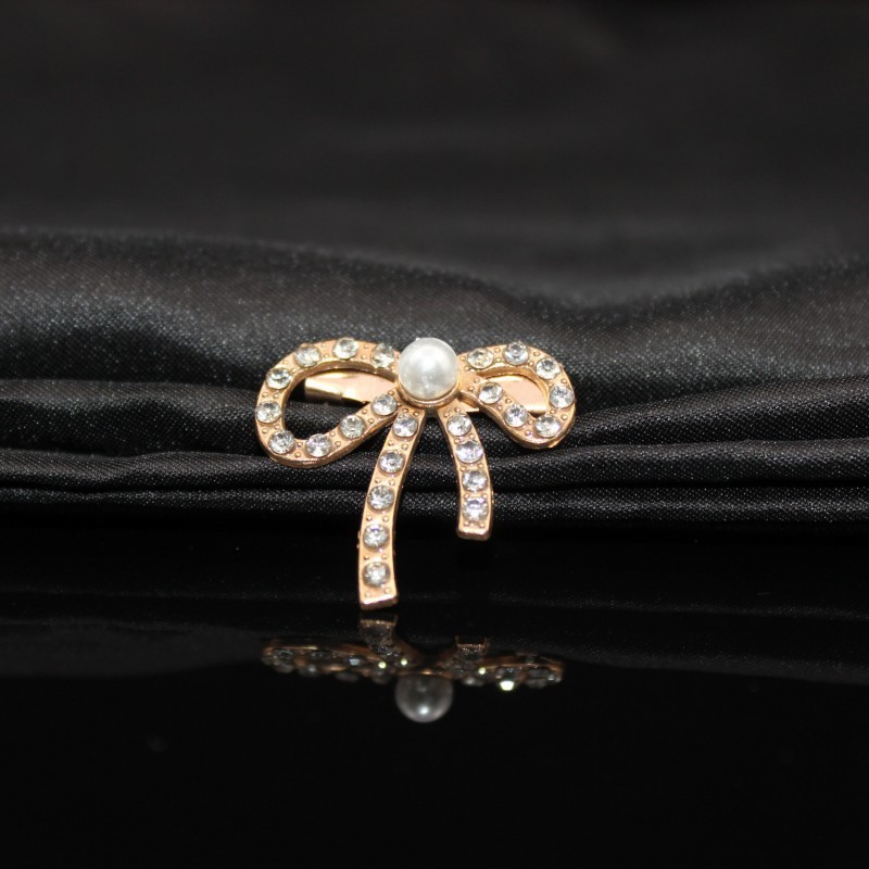 Metal brooch from pearl with bow