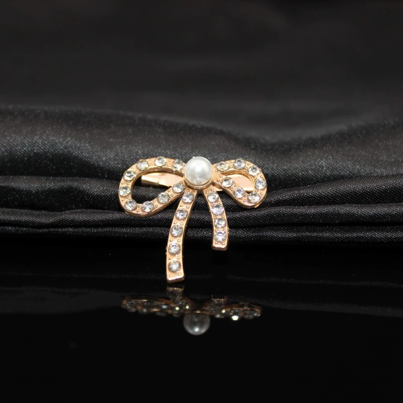 Metal brooch from pearl with bow