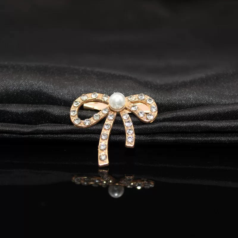 Metal brooch from pearl with bow