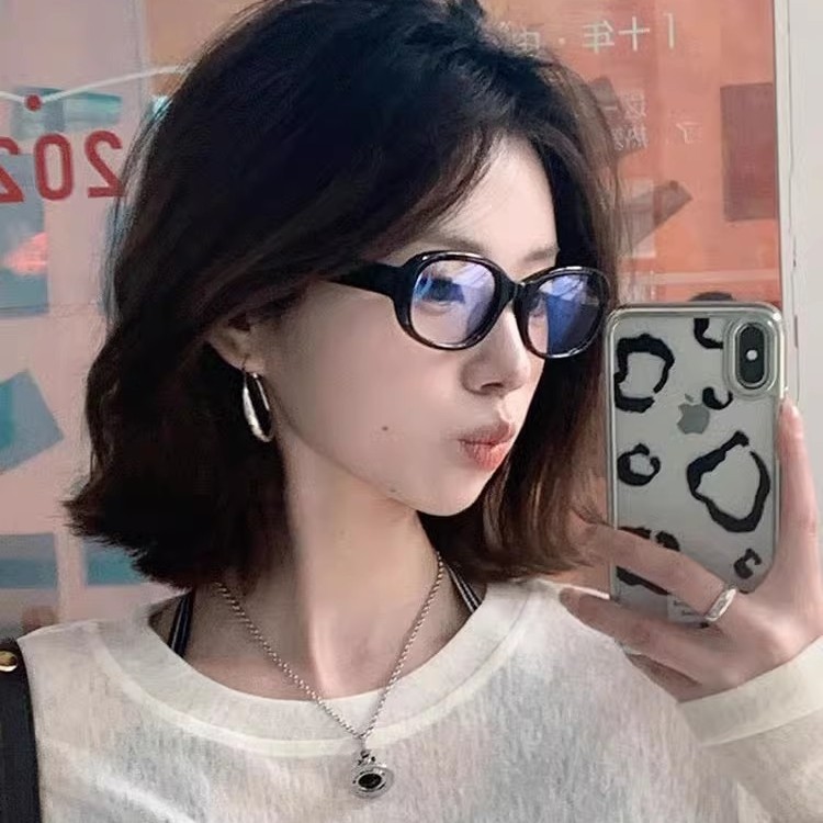 レトロな黒い枠のメガネの女性の近視は度数のすっぴんの神器の周囲の丸い顔を配合することができます。|undefined