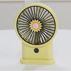 夏のかわいい子供が扇風機を持っています。