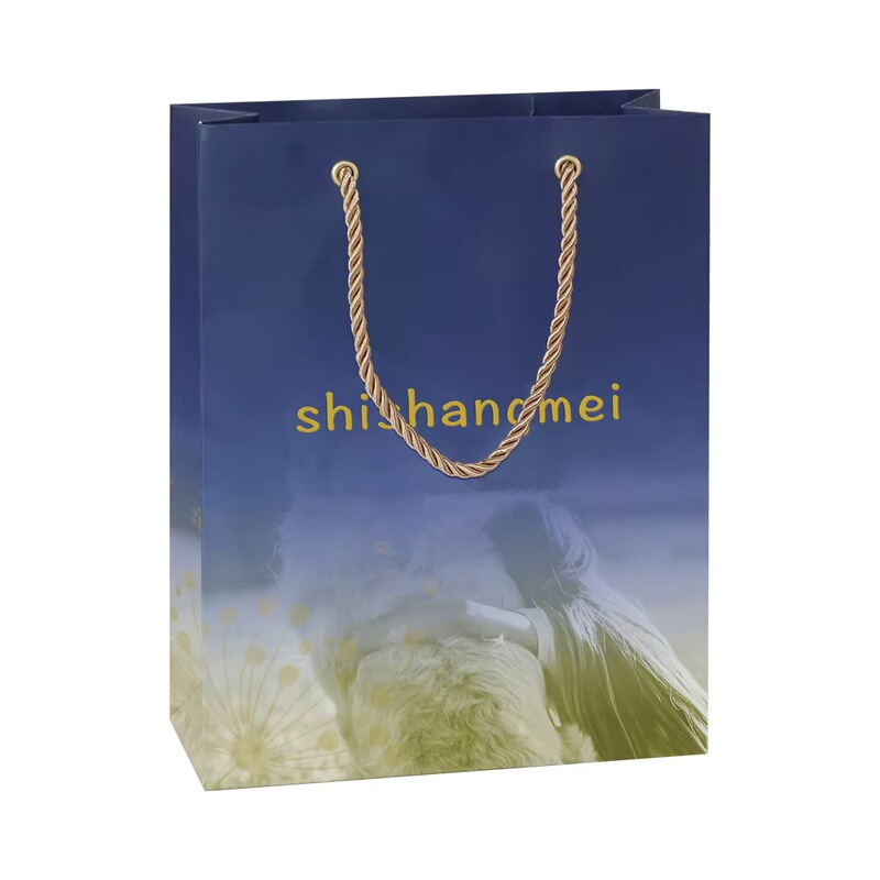 Gallery-style printed navy blue gradient matte C1S gift bag, featuring dandelion artwork and photos