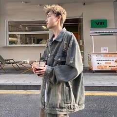 初秋の破れた穴のデニムのコートの男性の春秋のタイプのファッションのブランドの高級感のごろつきのハンサムでゆったりしているアメリカのジャケットの復古の上で服を着ます。