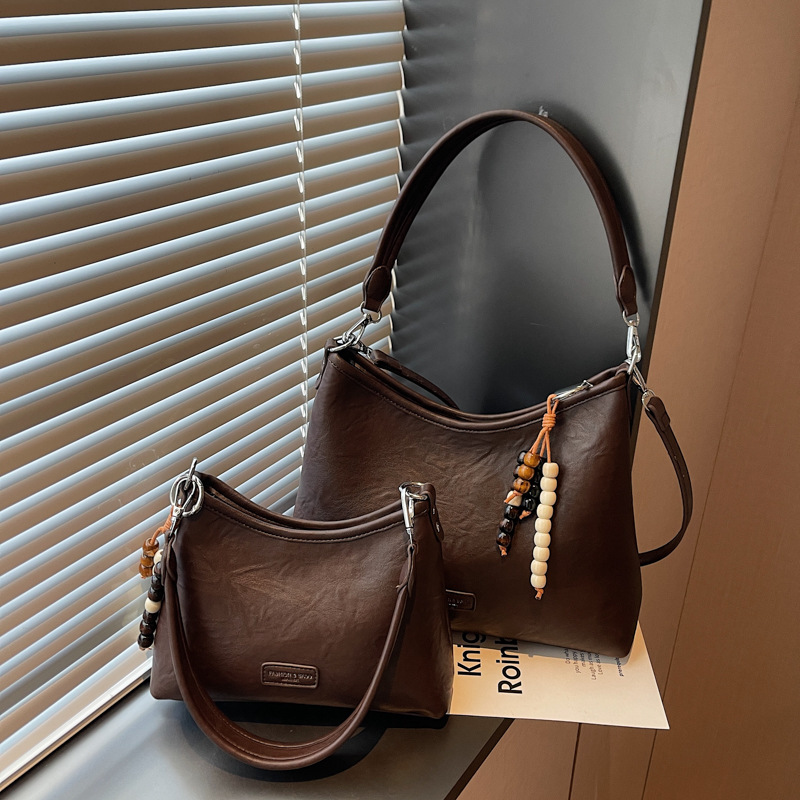 Bolsa de hombro con brazalete coreana de alto valor en otoño y invierno 2025 nuevo estilo retro simple bolso de mochila casual bolso de mano