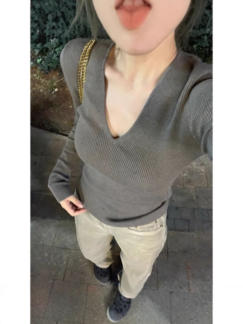 優しい風の純色のvネックのニットの女性の2024秋冬の新型の修身はやせている内に長袖の底のシャツのセーターを掛けます。